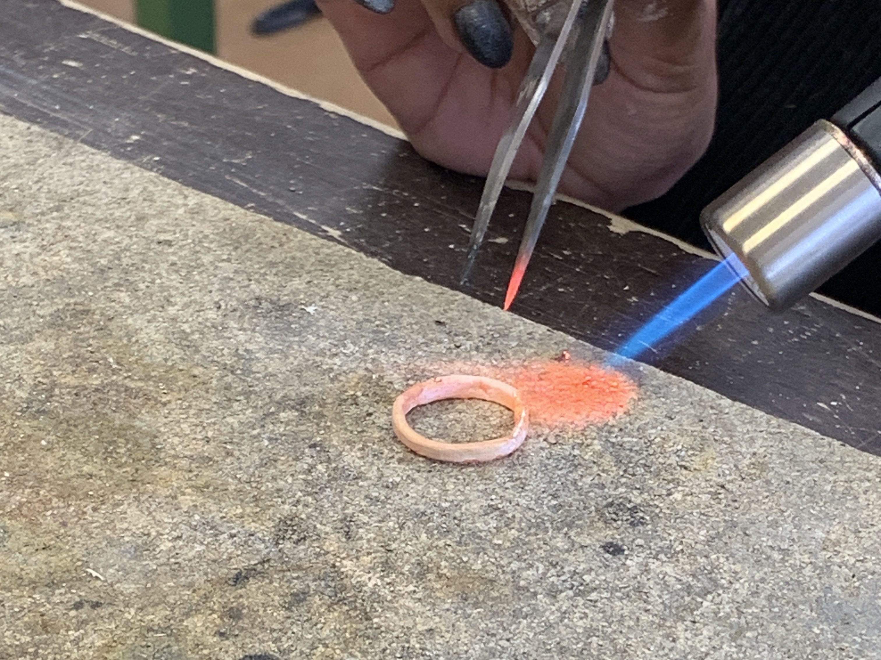 Das Foto zeigt einen leicht rot leuchtenden Ring der mit einem Bunsenbrenner erhitzt wird. 